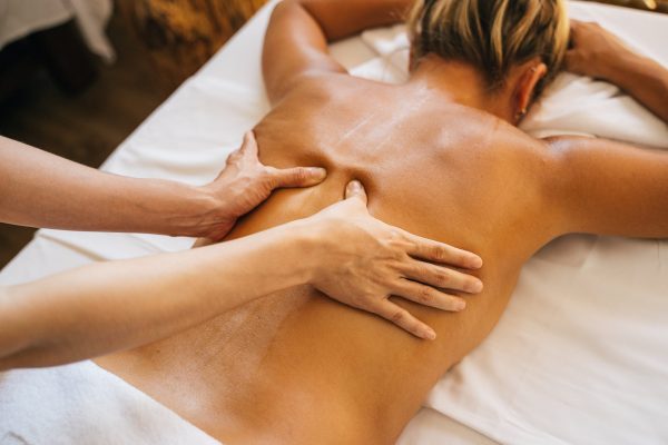 a-person-massaging-a-clients-bare-back
